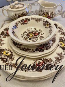 a vintage set of transferware dishes stacked together on a table