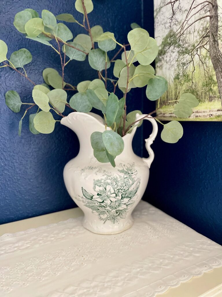 a vintage Ironstone pitcher with green transfer print displayed on a dresser