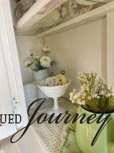 vintage Spring decor styled in a white hutch