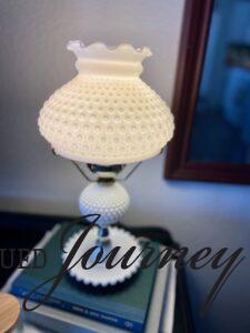 a vintage hobnail milk glass lamp turned on