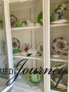 a white hutch styled for Spring with vintage and thrifted decor