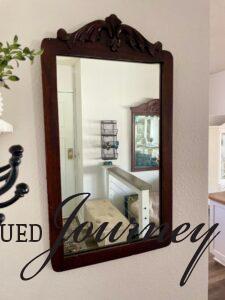 a vintage wooden mirror in an entry way