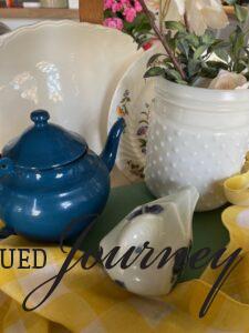 a vintage blue enamel teapot in a decorative basket