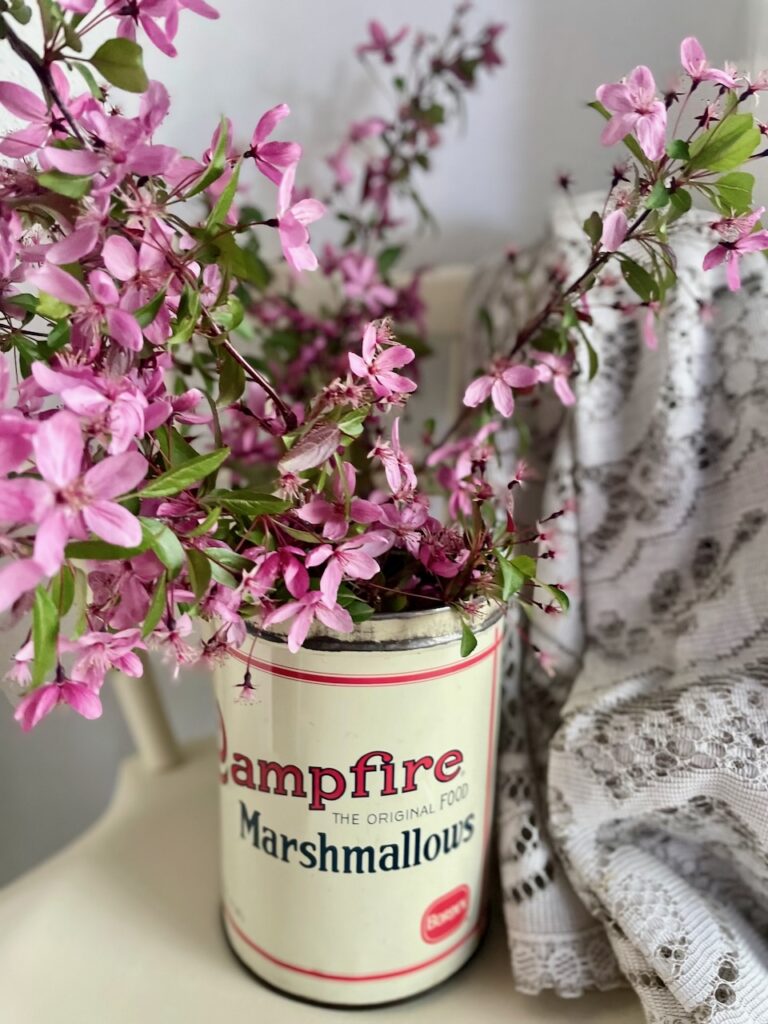 a flowering stem bouquet cut and placed in a vintage marshmallow tin for Summer