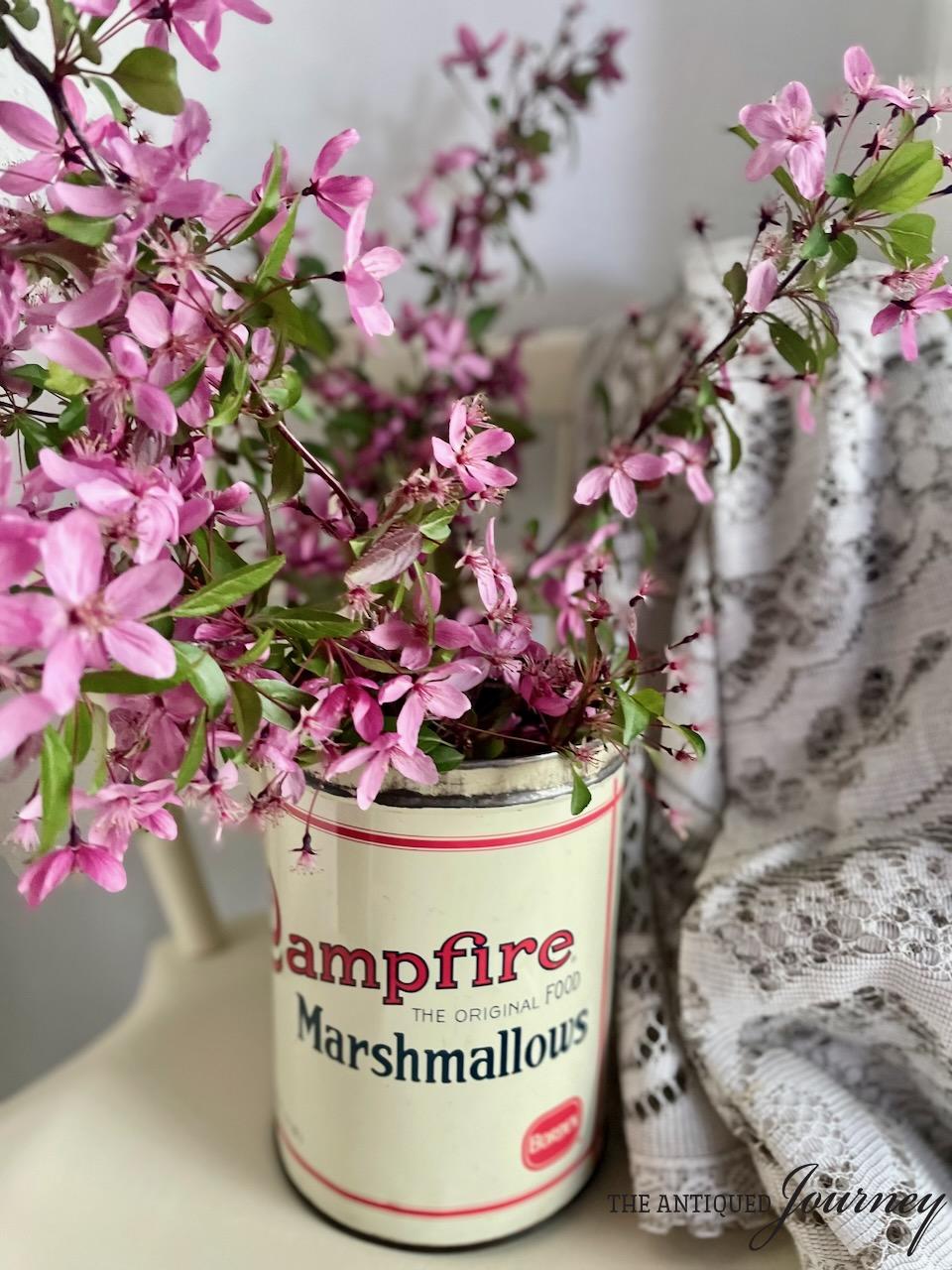 a flowering stem bouquet cut and placed in a vintage marshmallow tin for Summer