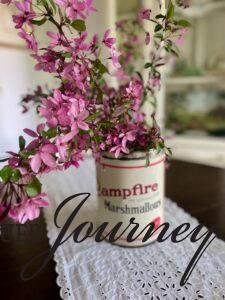 pink crabapple stems in a vintage marshmallow tin as a centerpiece