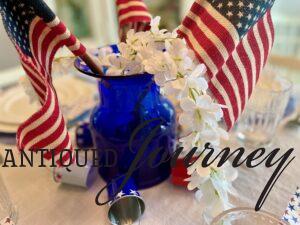 a vintage blue glass vase with flags and white flowers