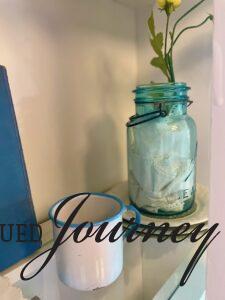 a vintage blue ball jar with faux yellow flowers