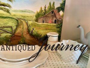 vintage dishes with a vintage barn artwork piece in a hutch for Summer