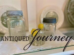 vintage glass jars and a flower frog in a Summer display