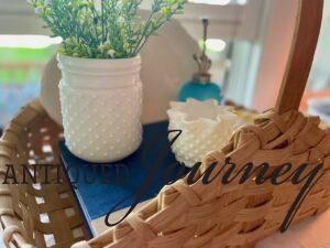 a thrifted basket styled with vintage milk glass