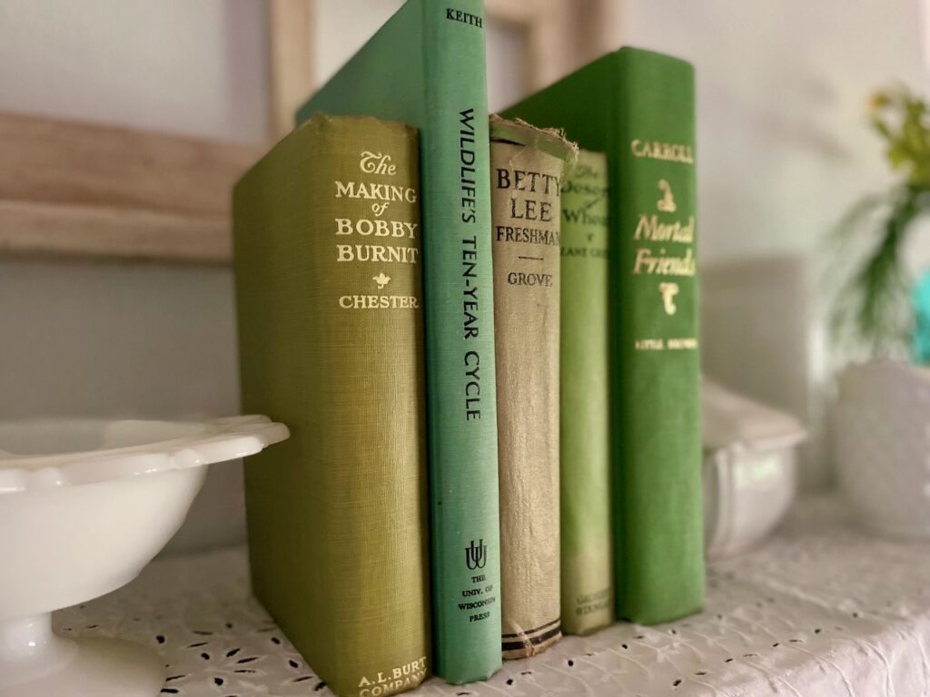 vintage green books styled on a shelf with vintage decor
