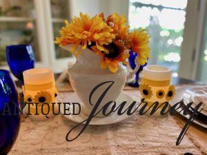 a sunflower centerpiece with vintage ironstone