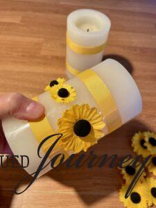 paper sunflowers attached to faux pillar candles for a centerpiece