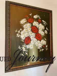 a thrifted vintage oil painting with red flowers