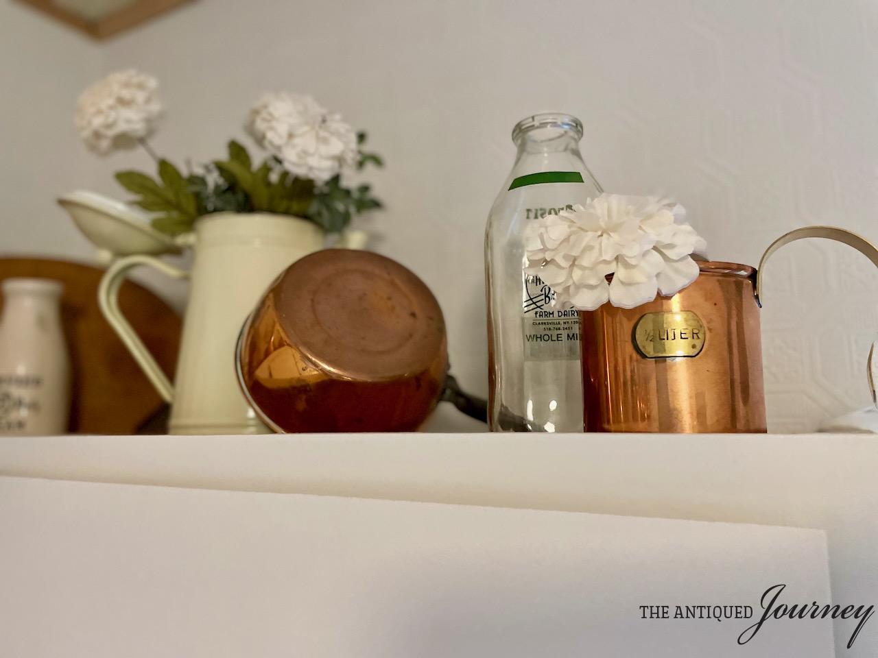 vintage copper displayed on a kitchen cabinet top