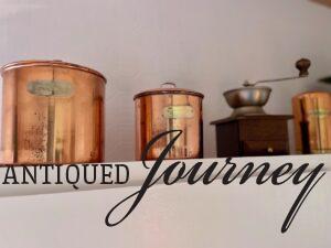 vintage copper canisters on top of kitchen cabinets