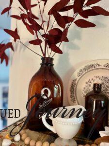 a vintage amber bottle with maroon eucalyptus stems for Fall decor