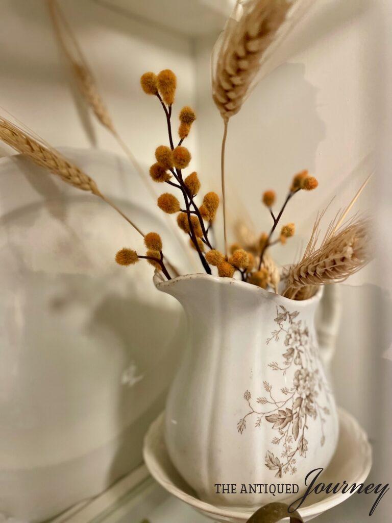 an antique transferware pitcher filled with faux wheat stems for Fall