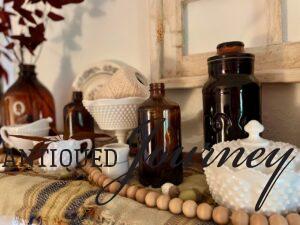 vintage Fall decor with amber bottles, milk glass and plaid 