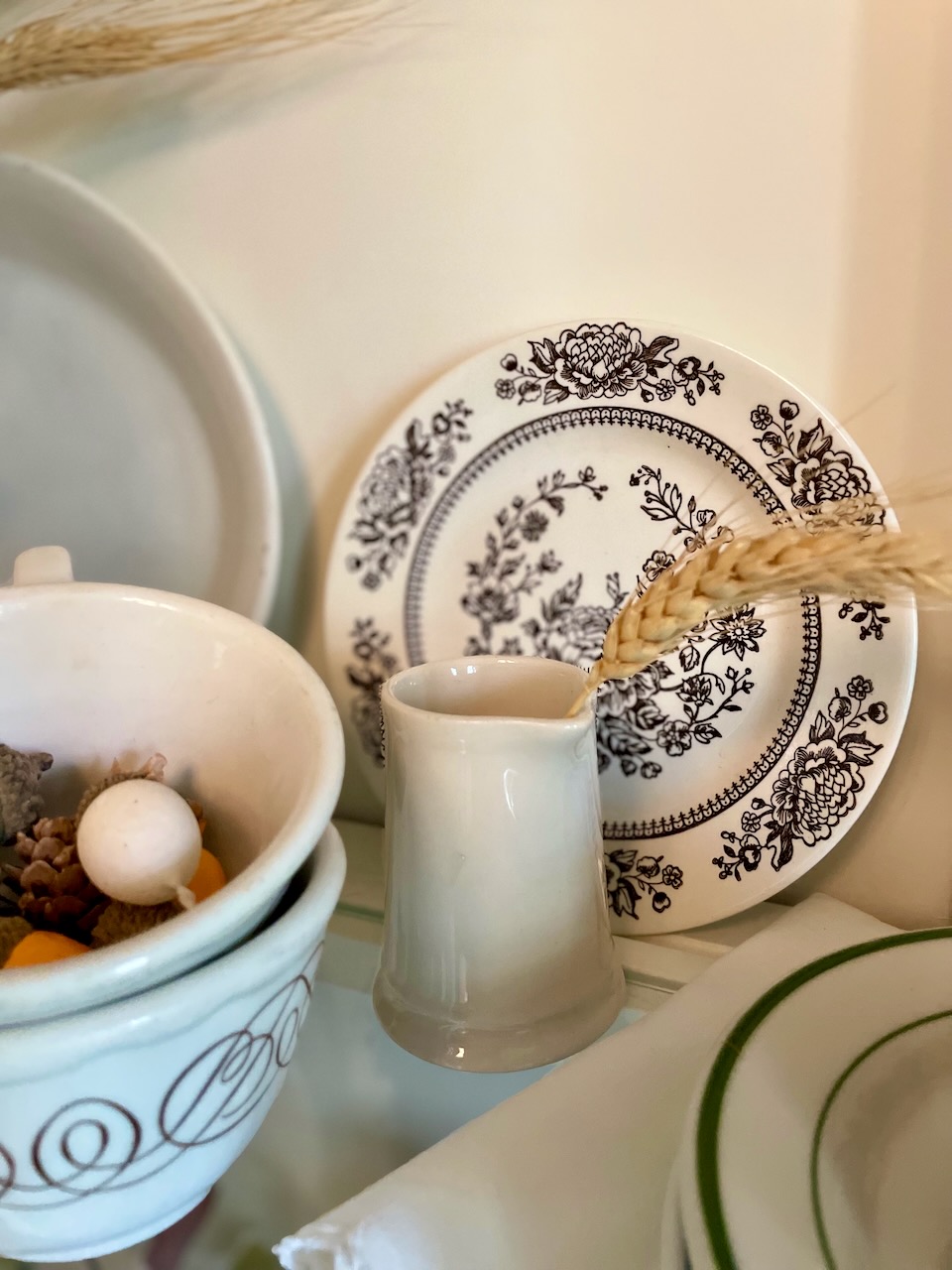 a vintage ironstone creamer and brown transferware plate in a hutch for Fall