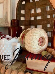 a vintage embroidery thread spool styled for Fall decor with a basket and milk glass
