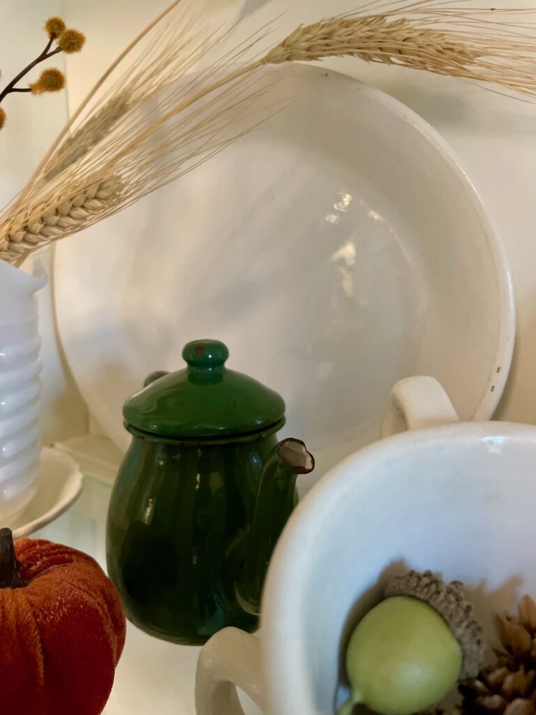 a vintage green enamel teapot styled in a hutch for Fall