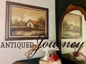 a vintage barn painting displayed as part of a mantel vignette for Fall