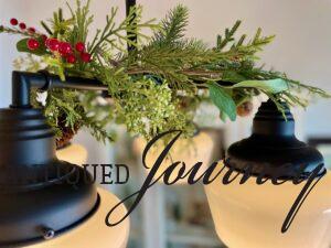 a black and white chandelier decorated for Christmas with a garland and red berries