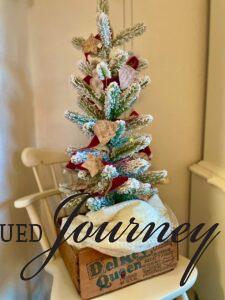 a DIY Christmas garland with vintage sheet music on a flocked tree