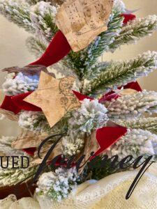 a finished DIY Christmas garland with vintage sheet music on a flocked tree