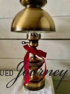 vintage brass lamp adorned with red ribbon