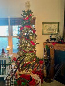 a slim faux Christmas tree with red ribbon