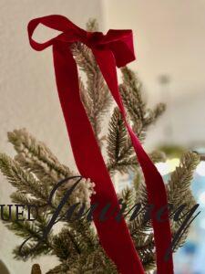 a flocked tree with red velvet ribbon for Christmas