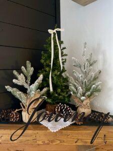 flocked and evergreen trees on a Winter mantel