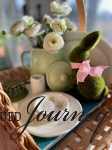 a Spring basket vignette with vintage dishes and a moss bunny