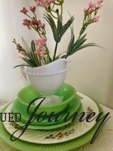 stacked jadeite dishes with pink flowers in a hutch
