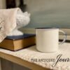 a blue and white enamel cup styled on a bathroom shelf