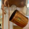 a vintage copper pint container hanging on a peg rack
